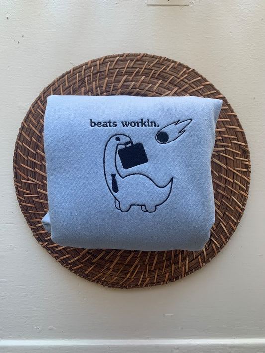 "Beats Workin" Dinosaur Embroidered Sweatshirt | Funny Minimalist Dino with Briefcase & Meteor | Dark Work Humor Gift for Adults
